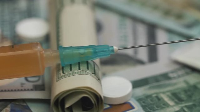 Pills, drugs, cocaine, syringe on dollar bank notes 