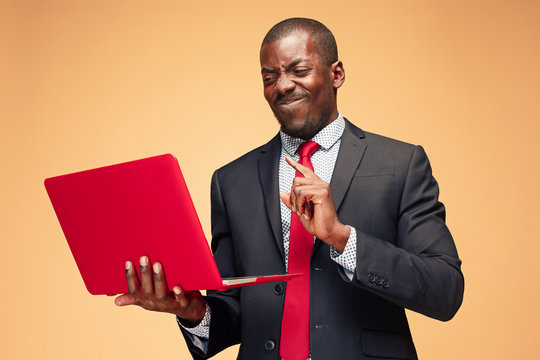 Handsome Afro American man sitting and using a laptop