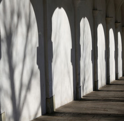 many shadows of a arcade with white wall