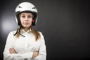 Ragazza con il casco simula felice la guida di una moto - sfondo nero