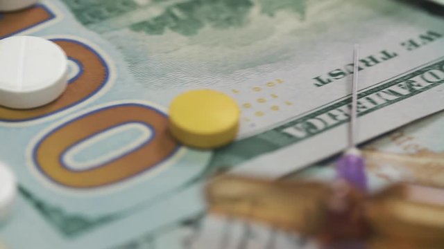 Pills, drugs, cocaine, syringe on dollar bank notes. Dolly camera