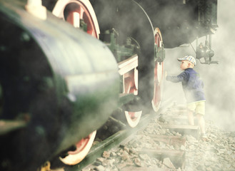 Little boy just about to touch a giant steam locomotive