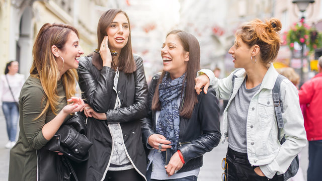 Four girls friends, gossip and having fun on the street