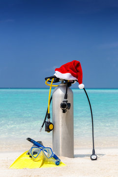 Taucherausrüstung mit Weihnachtsmütze am tropischen Strand