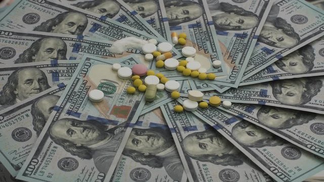 Drugs and pills for addiction lie on the thousands of paper dollars 