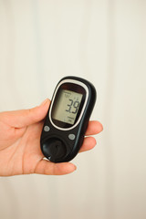 glucometer with result of measurement sugar level and tape measure, concept of diabetes