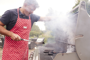 Middle aged man burning food on a barbecue