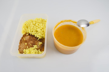 Plastic box with rice and meat and soup, isolated white background.