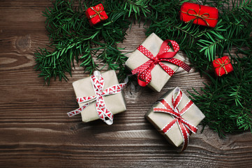 Fototapeta na wymiar Christmas handmade presents with red ribbon on wooden background