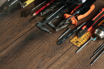 A construction tool on a brown wooden background. View from above. Picture background, screensaver. The concept of construction, repair, construction, production, design. Copy space.