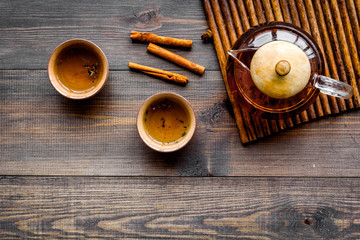 Tea break. Cookware fo tea ceremony. Tea pot and cups on dark wooden background top view copyspace