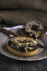 Dark moody shot of chocolate donuts with nuts