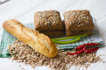 bread with sunflower seeds and baguette on wooden table