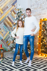 Christmas concept, fashion. father and daughter in elegant pullover posing in luxurious apartments decorated for Christmas. Hairstyle.