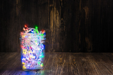 Christmas fairy lights in a glass jar. Home x-mas decor concept