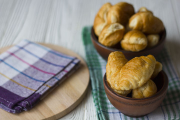 Fresh homemade croissants on white wooden table