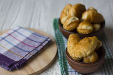 Fresh homemade croissants on white wooden table