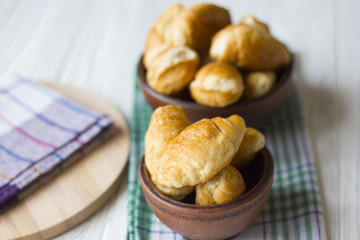 Fresh homemade croissants on white wooden table