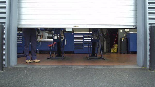 Jib shot of a mechanic opening a garage door