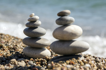 Fototapeta na wymiar Stones and pebbles stack, harmony and balance, two stone cairns on seacoast