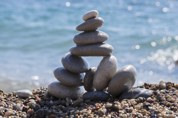 Fototapeta na wymiar Stones and pebbles stack, harmony and balance, One big pyramid stone cairn on seacoast