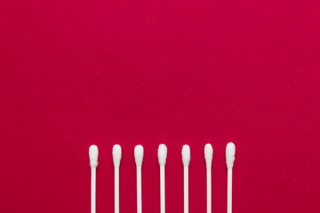 Hygienic, cotton buds on a red background. The concept of hygiene, cleanliness.