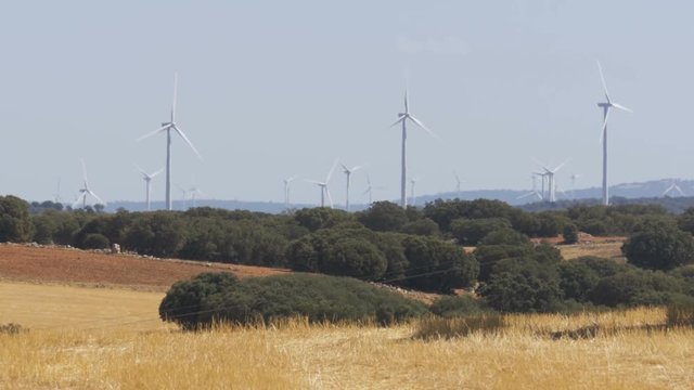 Wind Power in the Desert of Spain. Massive wind turbines generating power. Heat haze effect on desert land. Clean Energy producing of Windmills. Alternative power generation methods