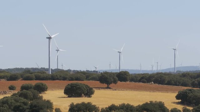 Wind Power in the Desert of Spain. Massive wind turbines generating power. Heat haze effect on desert land. Clean Energy producing of Windmills. Alternative power generation methods