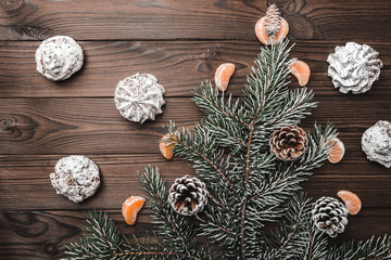 Brown wood background. Slice of mandarins. Fir tree and cones. Sweets. Christmas greeting card and new year. Xmas and Happy New Year composition. Flat lay, top view