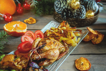 Quail stuffed with lemon and tangerine, roasted with red onions on the Christmas table.