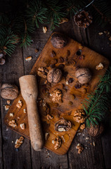 Whole and chopped walnuts with honey on vintage wooden background.Christmas mood, top view