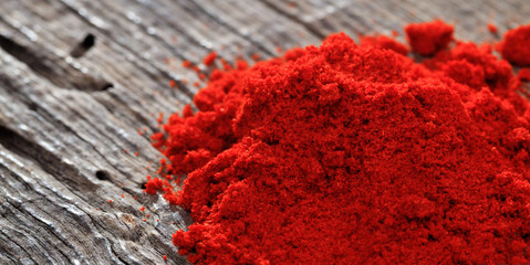 Paprika powder close up, on a wooden table, copy space