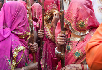 women in india dressed in traditional sari costumes during the holi festival in barsa and matura india - obrazy, fototapety, plakaty