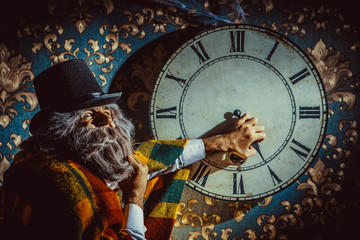 Senior caucasian man is trying to set the wall clock in the dark room.