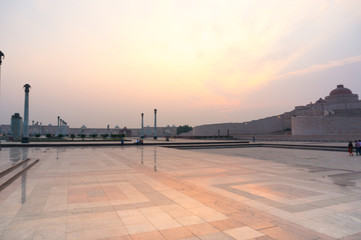 Wide angle shot of Ambedkar park with the beautiful orange light of sunset. The landscape of the park and the stupa in the background show off the huge size of the park