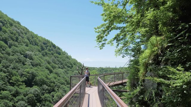 Young woman walks on observation deck. Okatse Canyon, near Kutaisi, Georgia