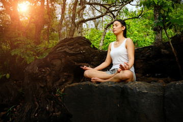 Woman training yoga and meditation on the rock at the mountain