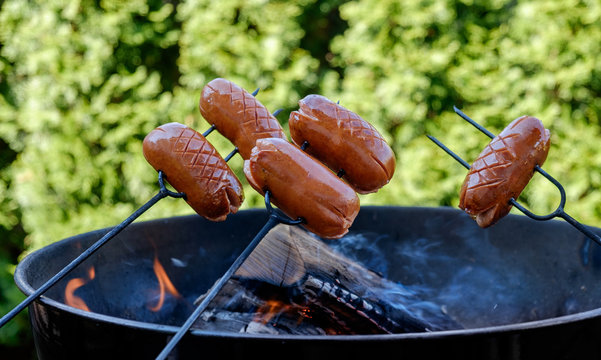 Preparing sausages on camp fire