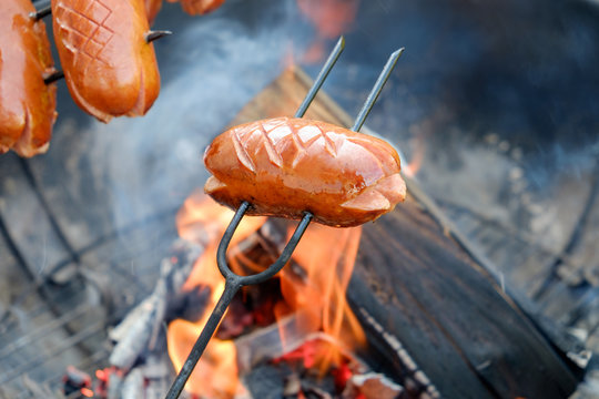 Preparing sausages on camp fire
