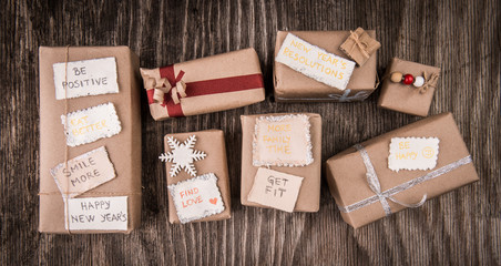Present boxes and new year goals on vintage wooden background
