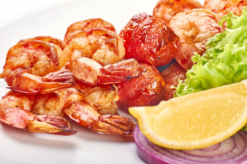 Appetizing fried shiny huge shrimp. Greens, lettuce, lemon, red onions as a side dish for royal prawns on the grill. Easy dietary healthy food for slimming people.