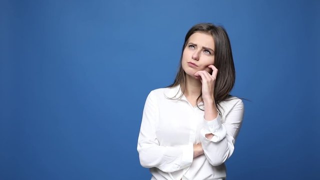 Young confused woman shrugging shoulders isolated