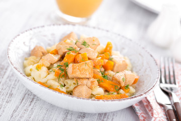 Braised chicken meat with carrot in sauce and pasta