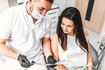 Dentist showing for the happy patient result of treatment