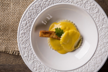 Ravioli stuffed with curd cheese in pumpkin sauce