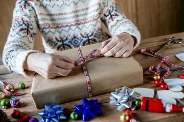 Fototapeta na wymiar Hands wrapping Christmas gifts