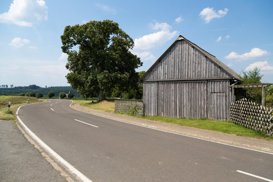 Old wooden barn along a rural road in Germany