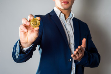 Fototapeta premium Golden Bitcoin in a man hand, Digitall symbol of a new virtual currency