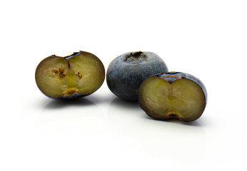 Bog blueberries isolated on white background one whole two sliced halves.