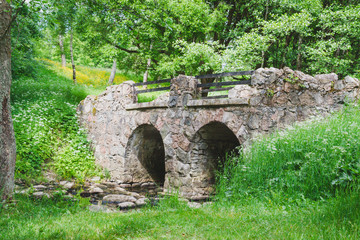 Fototapeta na wymiar Old stone bridge in summer Park